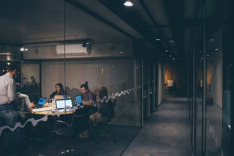 Gruppo di colleghi seduti intorno a un tavolo durante una riunione dedicata alla valutazione dello stress lavoro-correlato