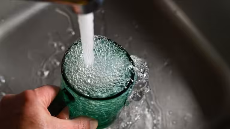 Acqua limpida che scorre dal rubinetto dentro un bicchiere, immagine legata alle analisi delle acque e alla qualità dell'acqua