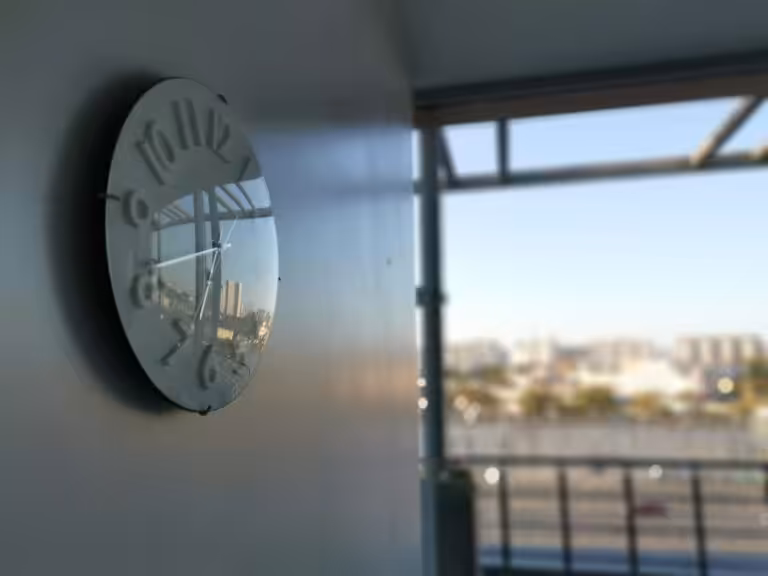 Orologio appeso alla parete di un ufficio a fine giornata lavorativa, immagine del tempo di lavoro legato a stress e rischi psicosociali