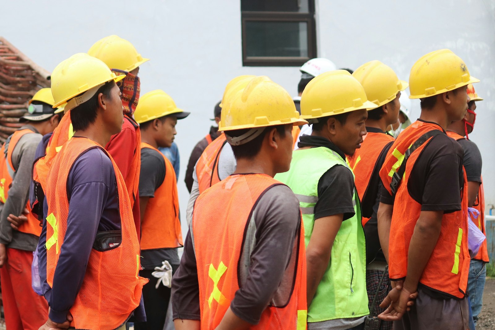 Lavoratore edile con casco e gilet ad alta visibilità durante un controllo in cantiere