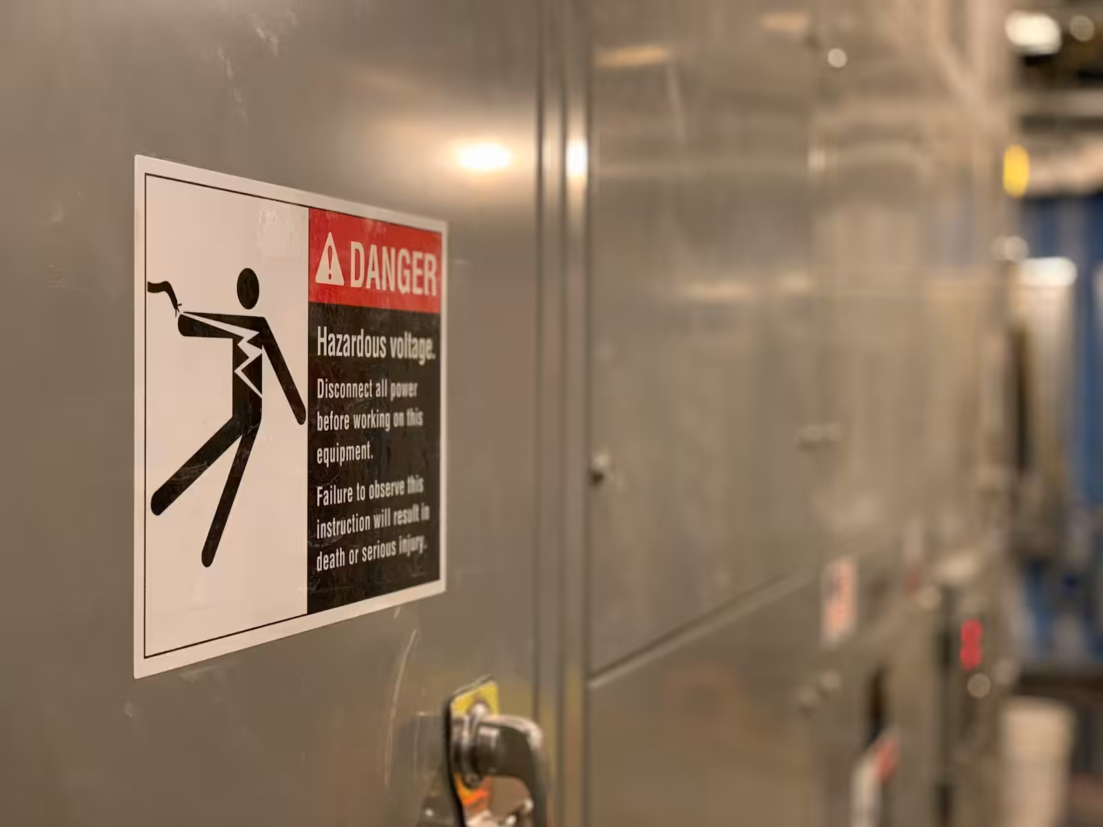 Cartello di pericolo tensione elettrica su un quadro: segnaletica di sicurezza sul lavoro
